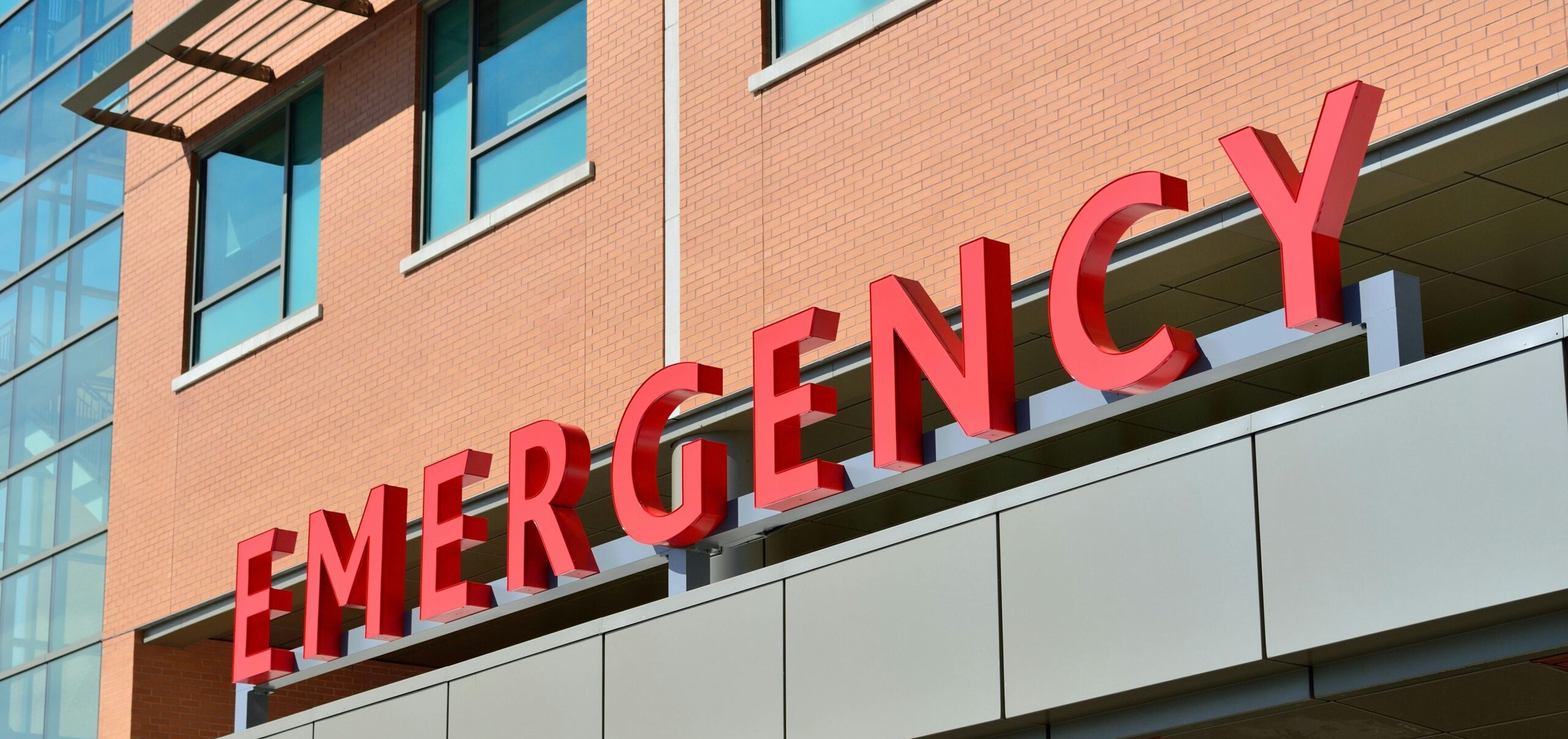 Close-up of a modern hospital emergency room entrance with prominent red letters.